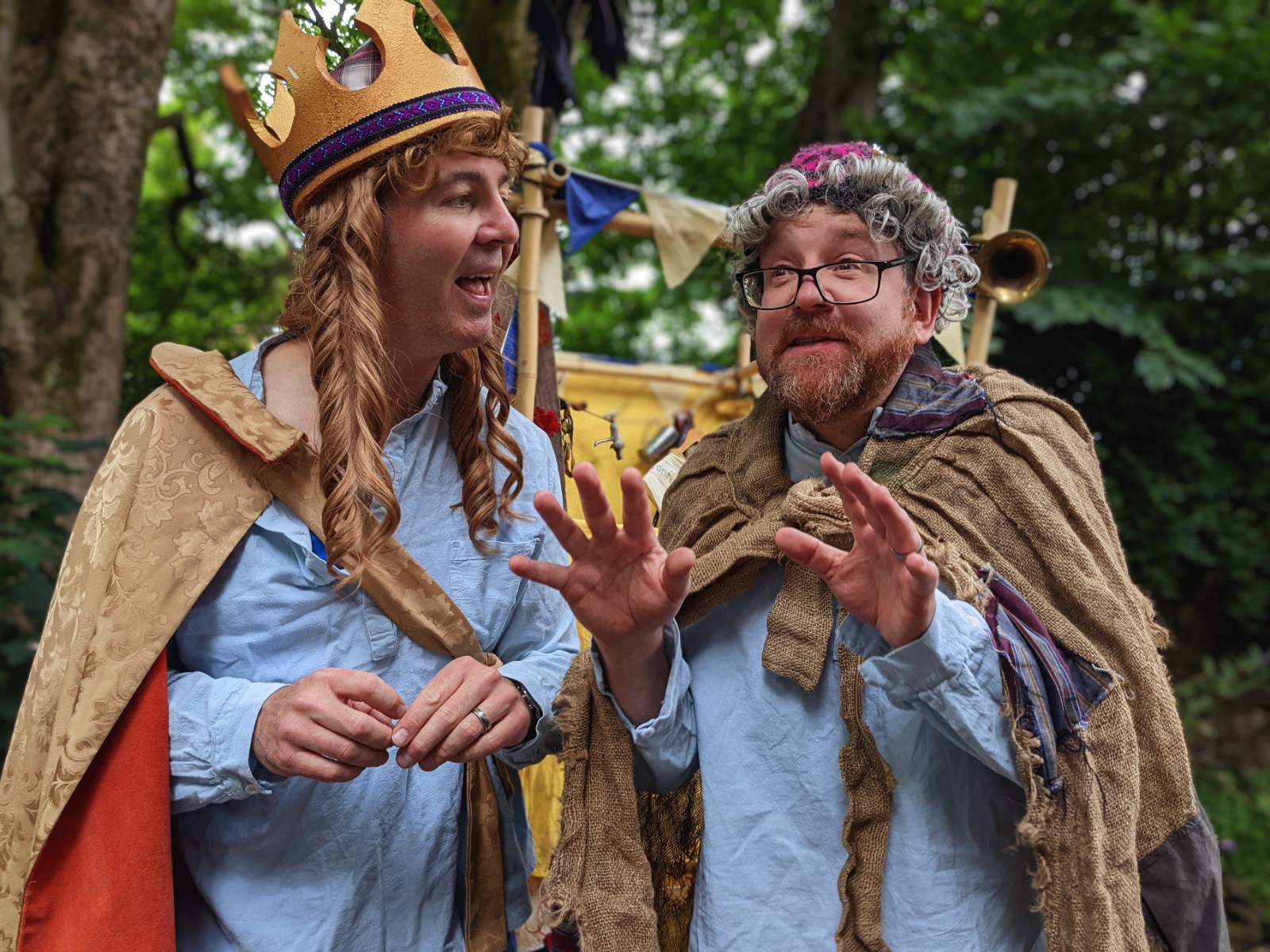 Two male actors are dressed as a queen and an old wise woman