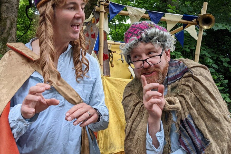 Two male performers, one dressed as a queen, the other as an old lady