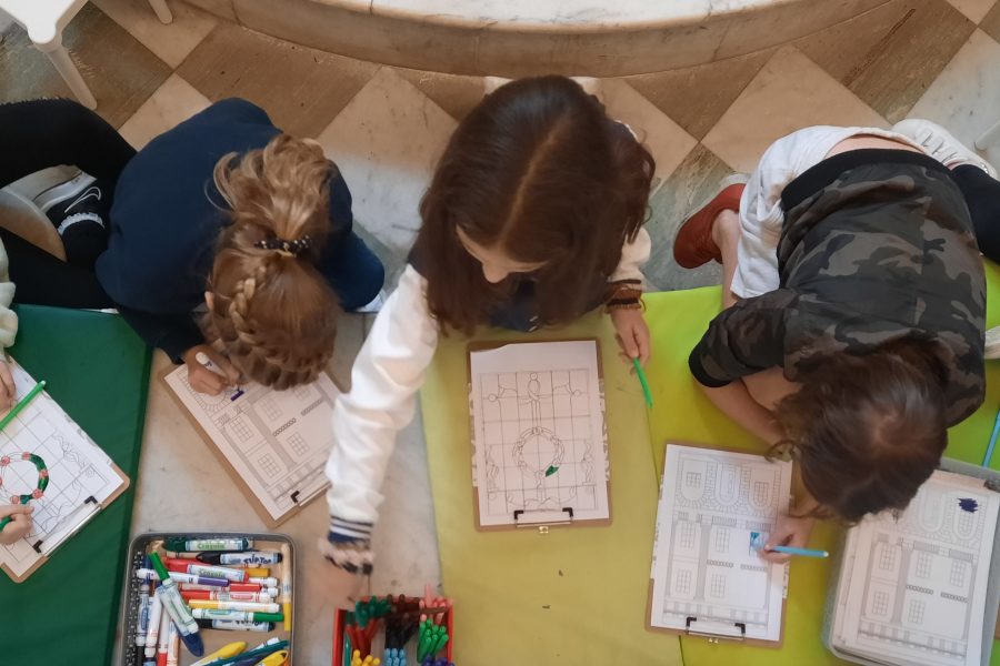 Photo taken from above looks down on a group of children colouring in