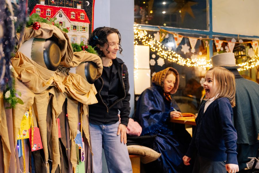 A small child is wide eyed with joy and excitement as she sees a large puppet come to life