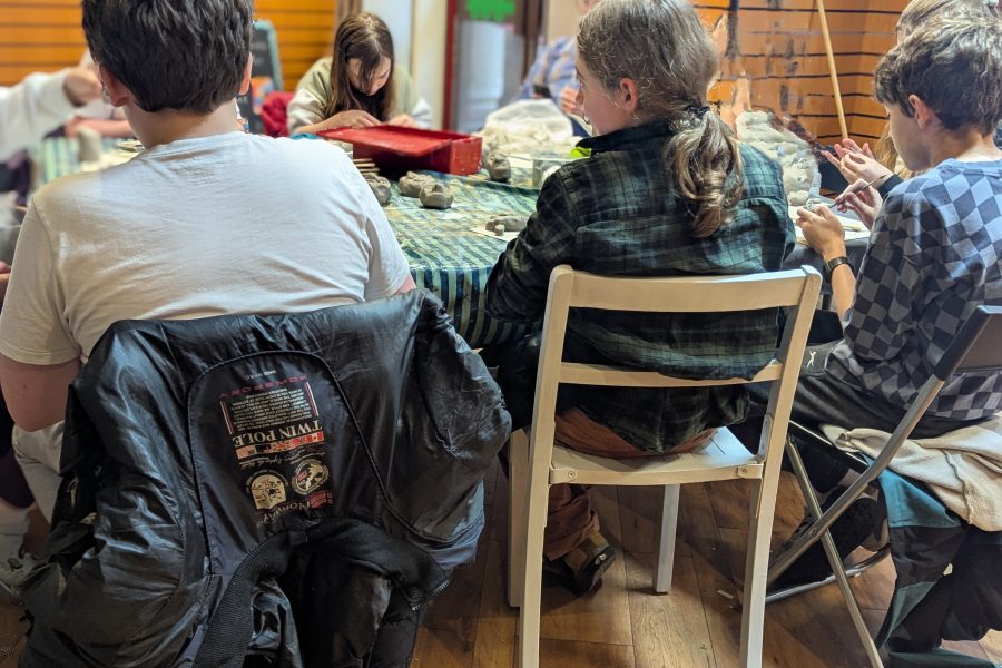 We see the backs of participants sat at a table and exploring the materials before them.