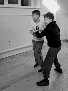 two boys are grabbing hold of one another as they act out a dram exercises and they look excited